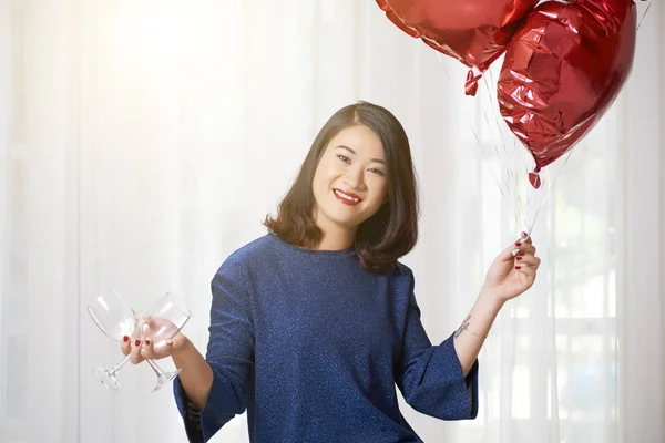 風船と つの空の使い捨てからす立っている 白い背景の上にカメラで笑顔の若い女性の肖像画 — ストック写真