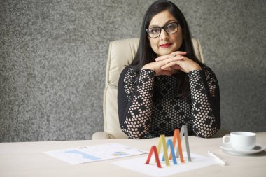 Portre profesyonel kadın mali Yöneticisi bu üzerindeki mali belgeler ile masada oturan 