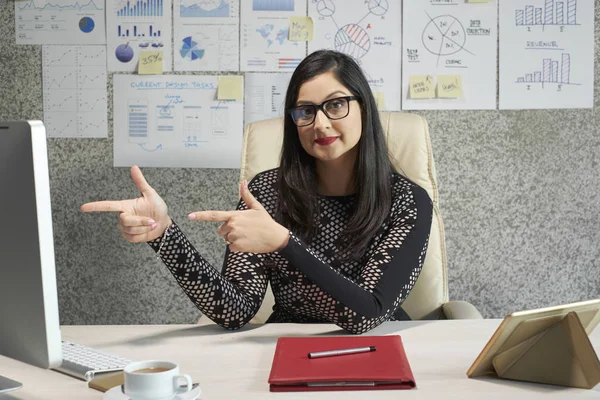 Businesswoman proud of her project pointing at computer monitor