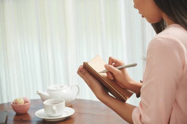 Çay içme ve planları ve fikirler günlüğüne yazma kadın 