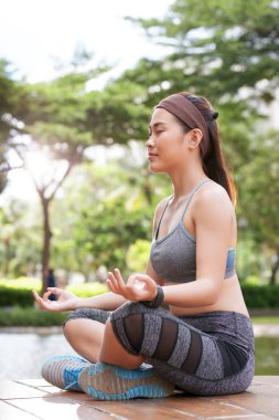 Gülümseyen park konumda lotus meditasyon pozitif Asyalı kadın 