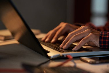 Gece geç saatlerde dizüstü bilgisayarda çalışan yazılım test adaptörü elinde
