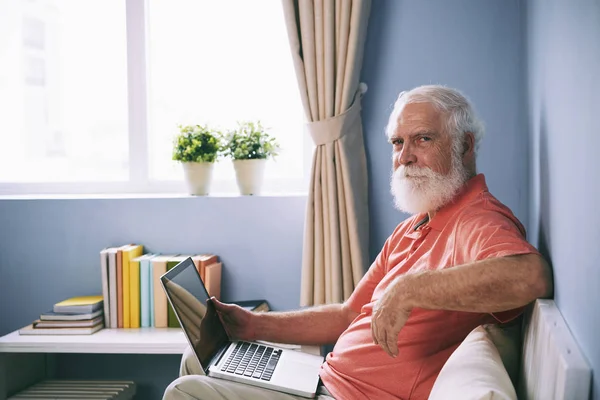 Portrait Confident Senior Man Sitting Sofa Laptop His Knees — Stock Photo, Image