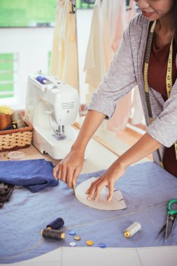 Elinde yeni pamuklu elbise için elbise detay özetleyen terzi