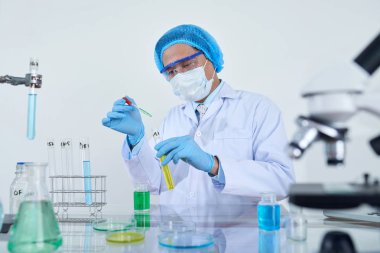 Mikro pipet bilim laboratuvar odasında kullanarak test sıvı ile çalışan bilim adamı araştırmacı adam