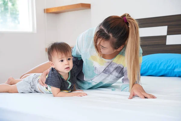 Joven Madre Comunicándose Descansando Cama Junto Con Pequeño Hijo — Foto de Stock