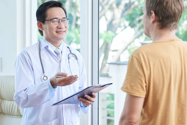 Asiático Médico Masculino Com Área Transferência Explicando Tratamento Para Paciente — Fotografia de Stock