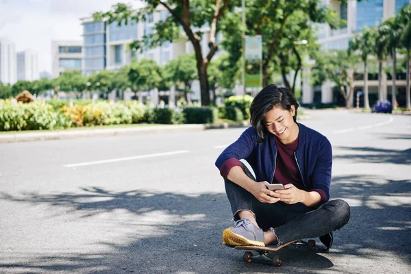 Allegro Bello Asiatico Uomo Seduto Skateboard Sms Amici — Foto Stock