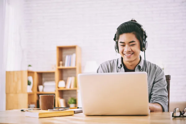 越南大学生在耳机工作的笔记本电脑在家里 — 图库照片