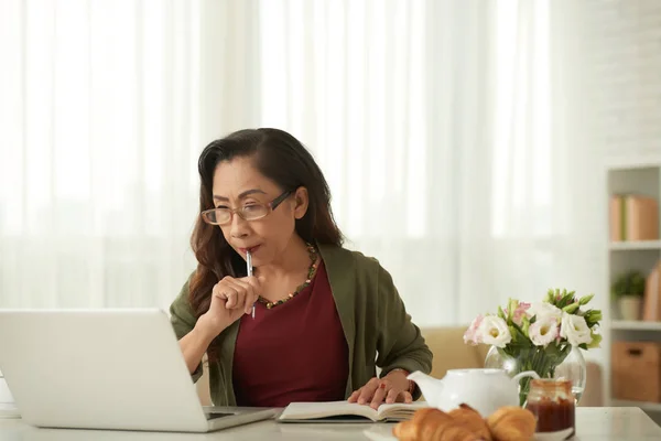 Senior Vietnamesische Frau Liest Informationen Auf Laptop Bildschirm Und Macht — Stockfoto