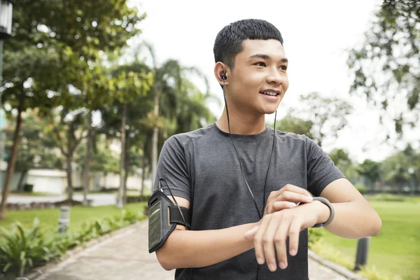 Veselá Vietnamský Muž Nastavení Fitness Tracker Před Běhání Venku Noci — Stock fotografie