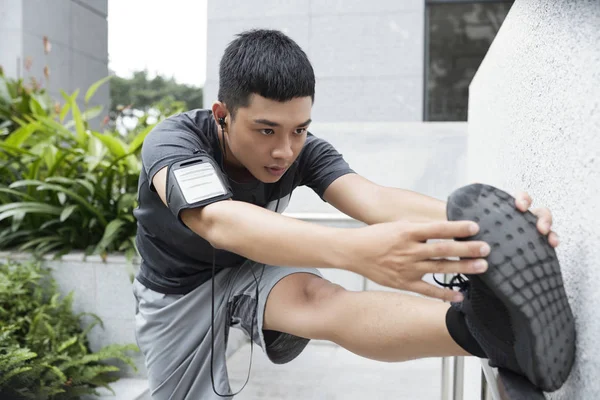 Vastberaden Jonge Aziatische Man Doen Oefeningen Zijn Benen Strekken — Stockfoto