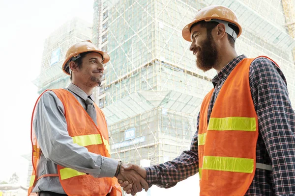 Trabalhadores Construção Sorrindo Apertando Mãos Para Cumprimentar Uns Aos Outros — Fotografia de Stock