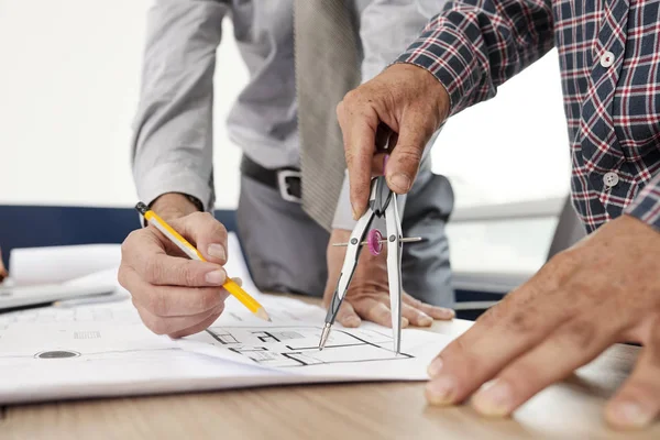 Händerna Ingenjör Som Arbetar Med Kompass När Checkar Mätningar Blueprint — Stockfoto