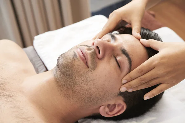 Jovem Deitado Relaxante Enquanto Massagista Profissional Fazendo Massagem Facial Cabeça — Fotografia de Stock