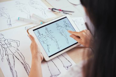 Anonim moda tasarımcısının modern tablet kullanma ve insan figürü çizimleri Studio masasında çalışırken seyir atış yukarıdan