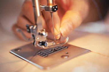 Anonim terzi koyarak ince iplik iğne modern dikiş makinesi atölye kontrolden closeup çekim