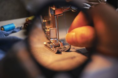 Pamuk iplik dikiş makinesi küçük Büyüteç camı arkasında iğne koyarak anonim terzi el