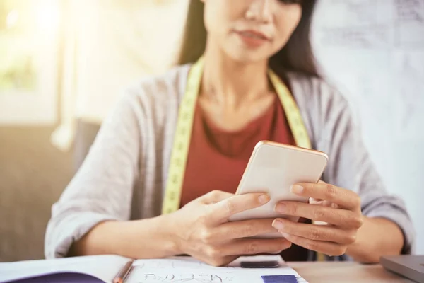 Anonimo Femminile Navigazione Smartphone Moderno Mentre Seduto Tavola Laboratorio Sartoriale — Foto Stock