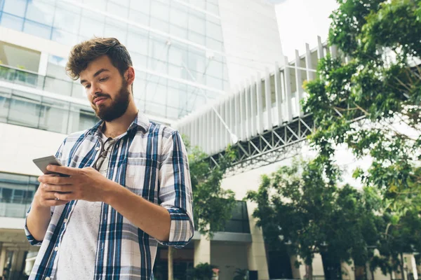 Mladý Muž Stojící Venku Pohyblivým Povrchem Mobilním Telefonu — Stock fotografie