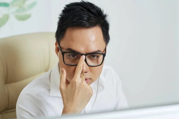 Frowning Young Businessman Adjusting Glasses Reading Report Computer Screen — Stock Photo, Image