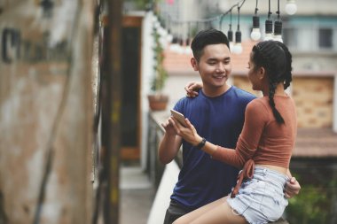 Genç Vietnamlı sarılma ve sohbet smartphone ile Çift