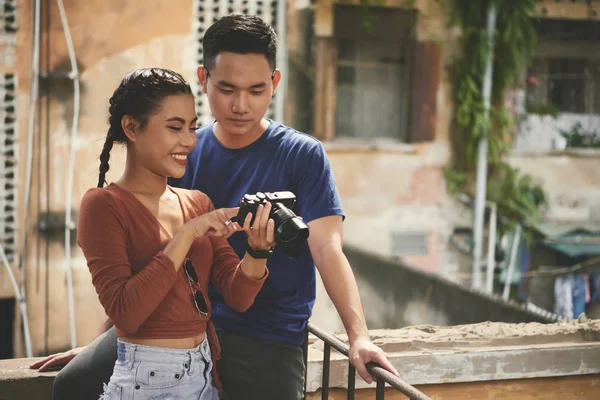 美丽的年轻亚洲夫妇检查他们在数码相机上拍摄的照片 — 图库照片