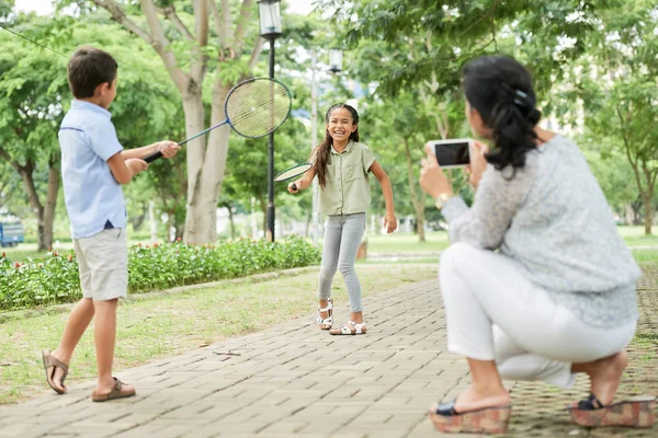 Felnőtt Használ Smartphone Kép Vidám Ázsiai Gyerekek Játék Tollaslabda Park — Stock Fotó