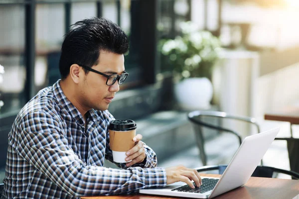 Ασιατικό Νεαρό Άντρα Πίνοντας Καφέ Και Δουλεύοντας Φορητό Υπολογιστή — Φωτογραφία Αρχείου