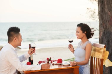 Plaj romantik akşam yemeğinde iyi şarap zevk neşeli genç Asya Çift