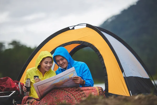 Sorrindo Casal Asiático Capas Chuva Sentado Perto Tenda Procurando Maneira — Fotografia de Stock