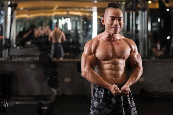 Alegre Jovem Asiático Fisiculturista Tensionando Músculos Frente Espelho — Fotografia de Stock