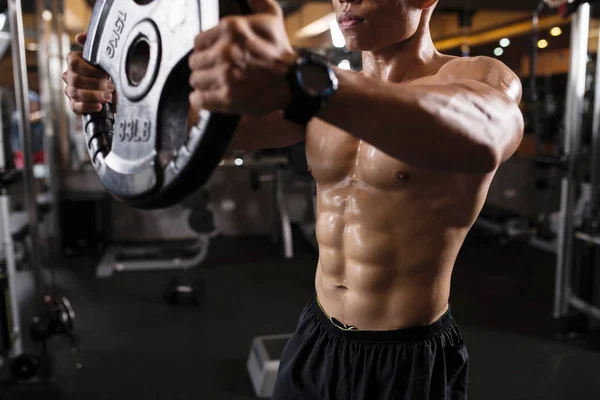 出汗的年轻人在健身房锻炼手臂和胸部 — 图库照片