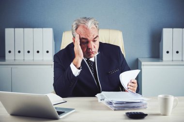 Onun önünde belgelerin yığını bakarak bored mutsuz işadamı 