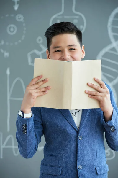 Cheerful Vietnamese High School Student Hiding Opened Book — Stock Photo, Image