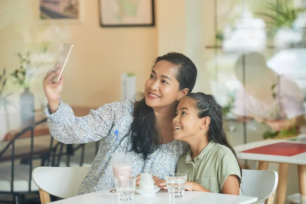 微笑的母亲在咖啡馆里和女儿一起自拍 — 图库照片