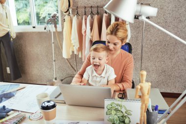 Moda Stüdyosu sahibi bilgisayar üzerinde çalışan oğlu ile onu Tur oturan
