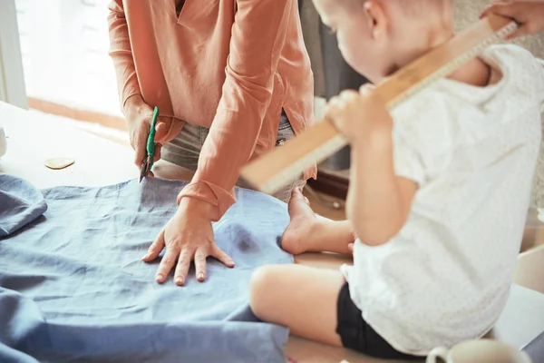 Niño Mirando Cómo Madre Cortando Tela Estudio — Foto de Stock