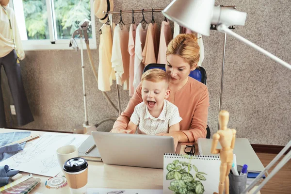 Moda Stüdyosu sahibi bilgisayar üzerinde çalışan oğlu ile onu Tur oturan