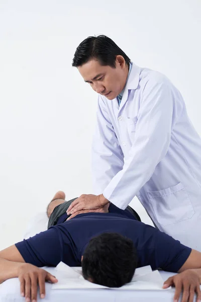 Rijpe Aziatische Chiropractor Aanpassen Wervelkolom Van Jonge Patiënt — Stockfoto