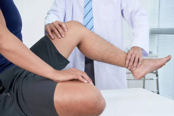 医生检查急性疼痛患者的腿部 — 图库照片