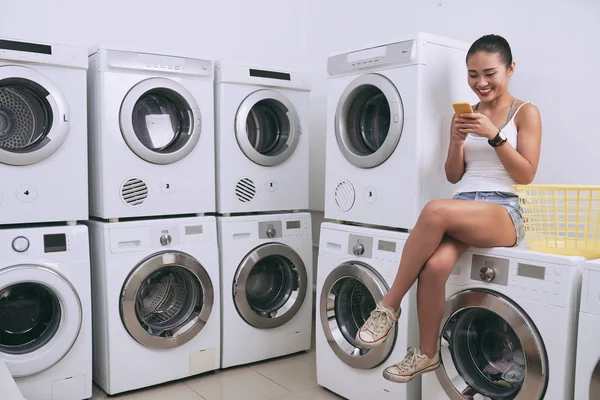 Mujer Vietnamita Bastante Sonriente Sentada Lavadora Sala Lavandería Mensajes Texto —  Fotos de Stock