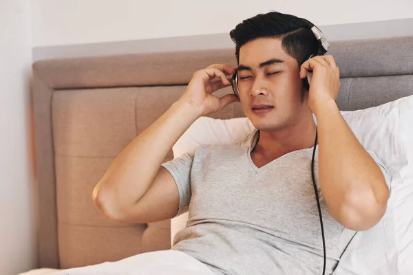 Atrakcyjny Młody Asian Mężczyzna Ciesząc Się Muzyką Utwór Jego Słuchawkach — Zdjęcie stockowe