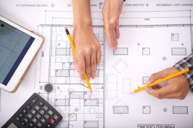 Kalem tutan ve tablet ve hesap makinesi yakınında şema notları yapma anonim meslektaşlarının elleri yukarıda çekim