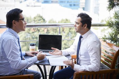İki olgun ofis çalışanları açık gün planlayıcısı ile kafede masada oturan ve birlikte yeni iş planı tartışıyor