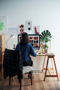 Yaratıcı kadın onun ev ofisinde web sitesi arayüzü üzerinde çalışan, arkadan görünümü