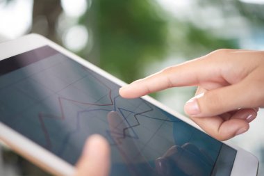 Bulanık arka planda modern tablette veri kaydırma anonim kişinin ellerinin yakın çekim 