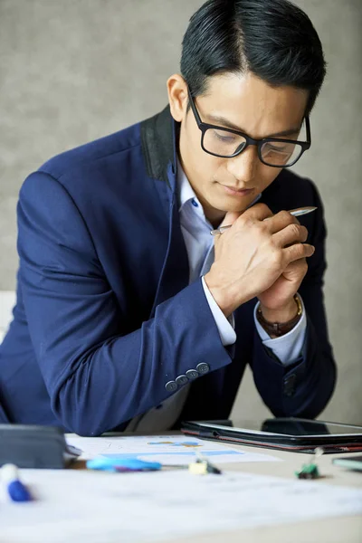 Nachdenklicher Vietnamesischer Jungunternehmer Mit Brille Liest Informationen Auf Tablet Computer — Stockfoto