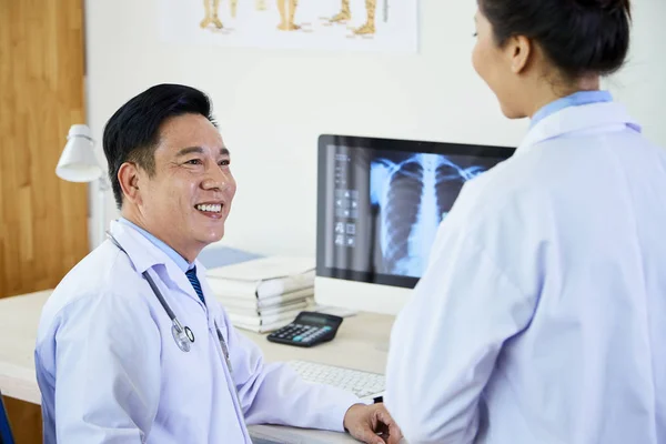 成熟的亚洲医生与X光图像和微笑 而在医院交谈 — 图库照片