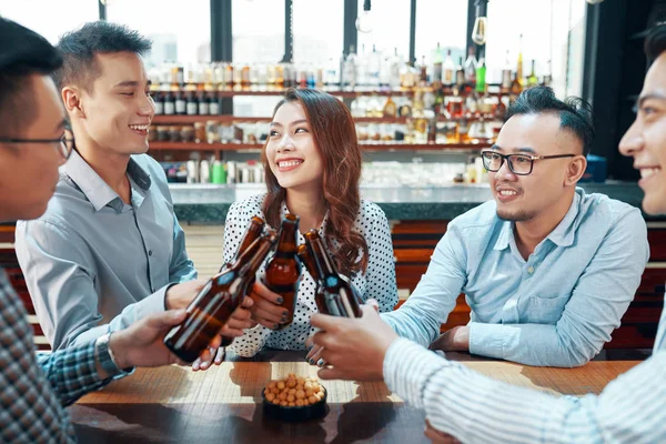 Bira Şişeleri Ile Kutlayan Iyi Arkadaşlar Gülümseyerek Masada Oturan — Stok fotoğraf